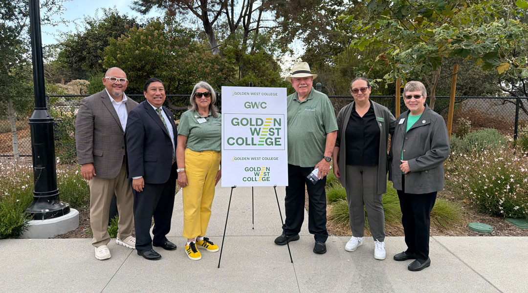 Coast District Trustees and Chancellor standing outdoors with GWC President Meridith Randall beside a sign on an easel that reads “Golden West College.”
